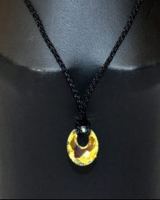 A Swarovski crystal circle pendant necklace on a black mannequin.