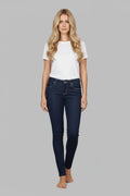 Woman wearing a white t-shirt and dark blue jeans on a gray background