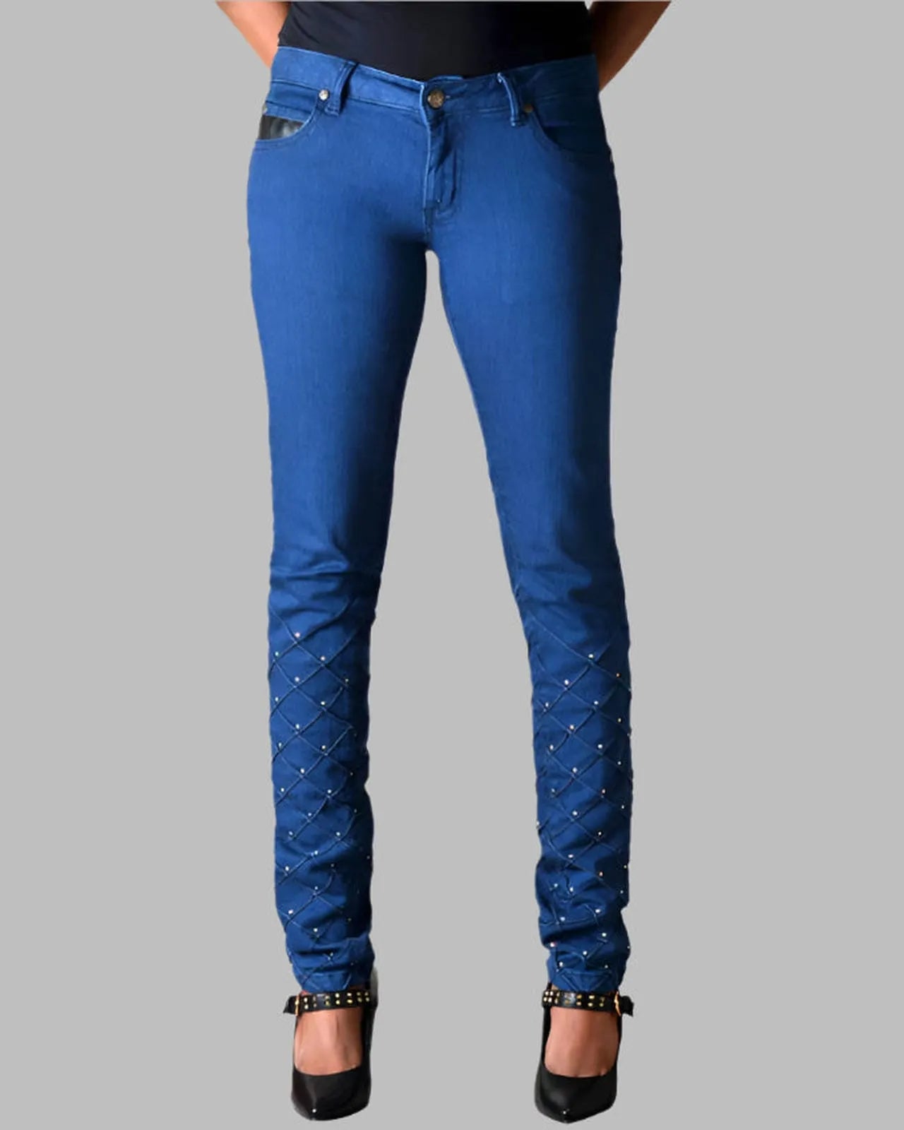 Blue jeans with embellishments on a gray background