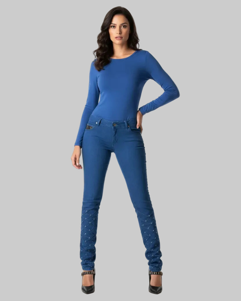 Woman wearing a blue long-sleeve top and jeans on a white background