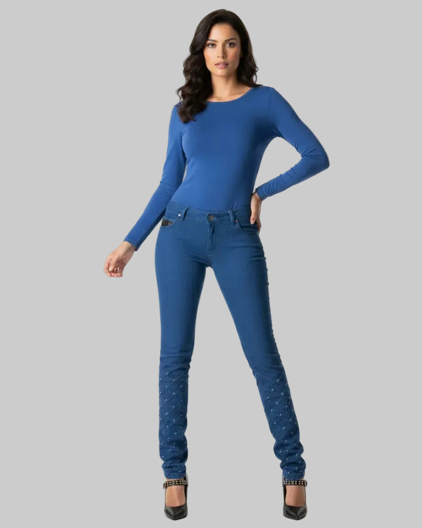 Woman wearing a blue long-sleeve top and jeans on a white background