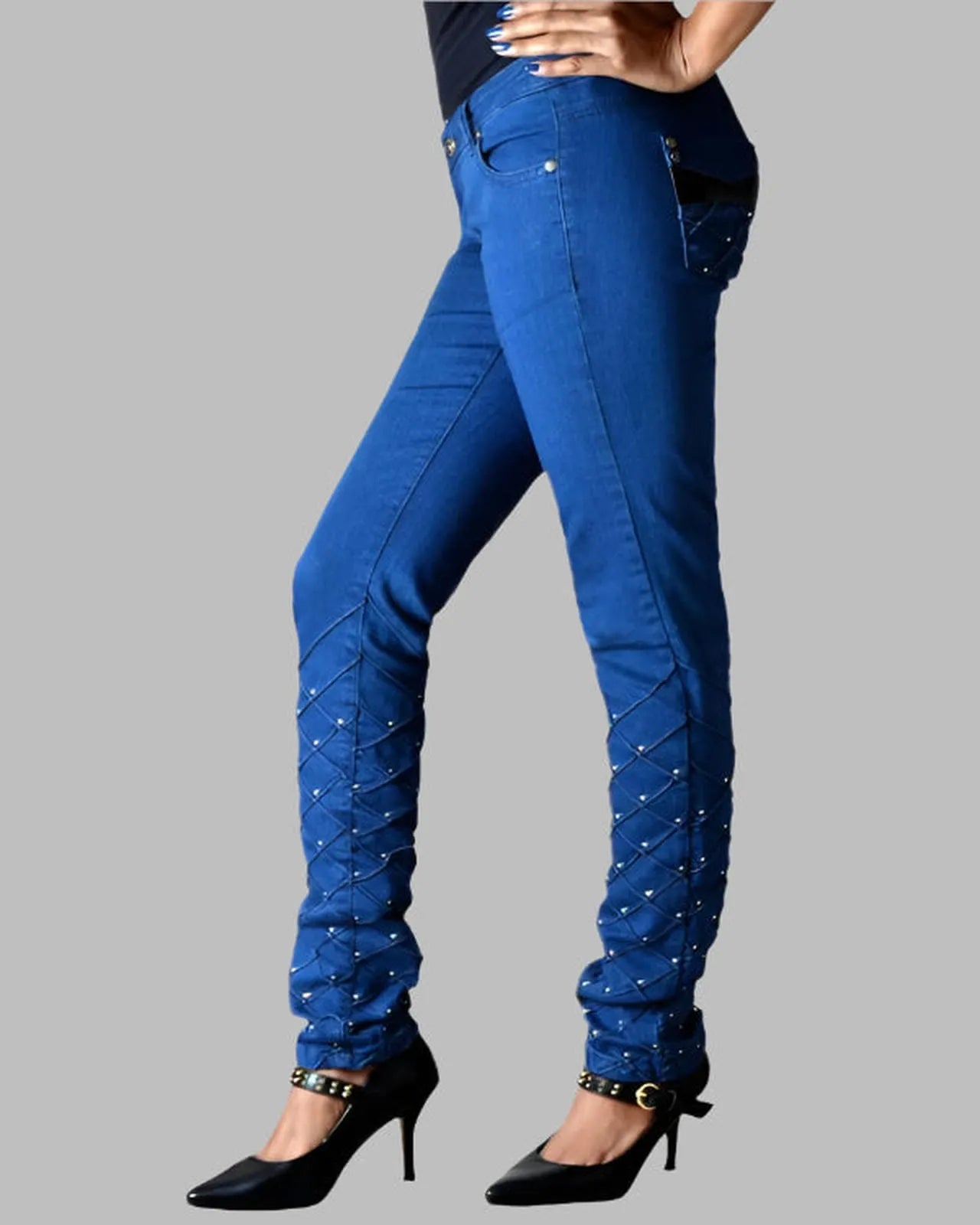 Blue jeans with embellishments on a gray background
