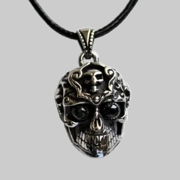 Skull pendant necklace on a black cord against a white background