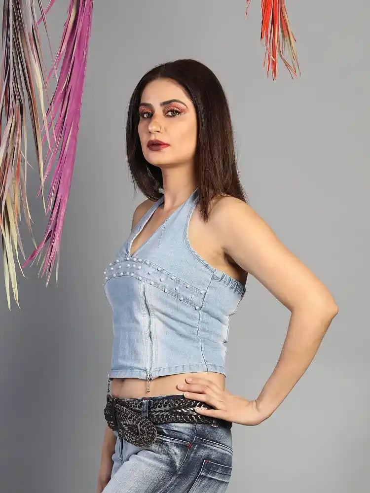 Woman wearing a light blue top and jeans with a gray background