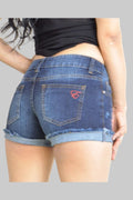Person wearing blue denim shorts with a visible brand logo on a plain background