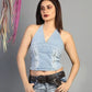 Woman wearing a light blue top and jeans with a gray background