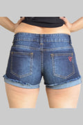 Person wearing blue denim shorts with a visible brand logo on a plain background