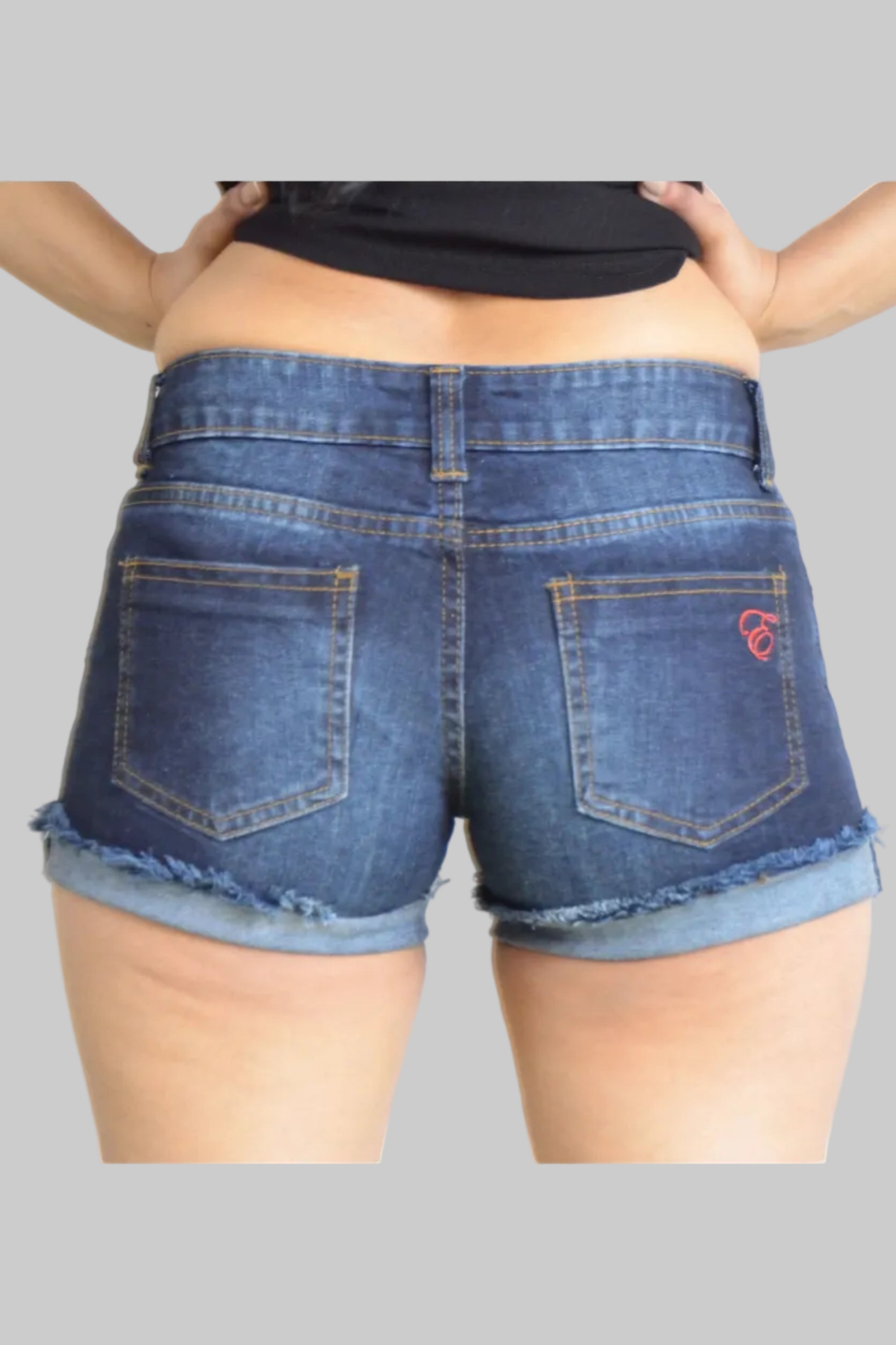 Person wearing blue denim shorts with a visible brand logo on a plain background