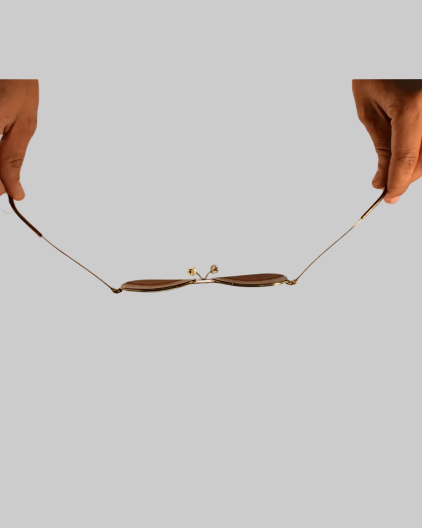 Two hands holding a delicate necklace on a white background