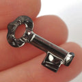 Close-up of a silver key held between fingers with a blurred background