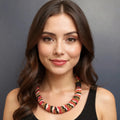 Woman wearing a colorful beaded necklace against a gray background