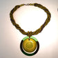 Green beaded necklace with a circular pendant on a light background