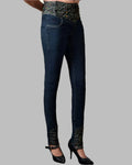 Dark blue jeans with patterned waistband and hem on a gray background