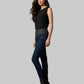 Woman wearing a black sleeveless top and dark blue jeans on a gray background