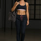 Woman in athletic wear holding a bag in a dark room
