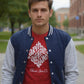 Man wearing a red shirt with white text and a blue and gray varsity jacket on a sidewalk.