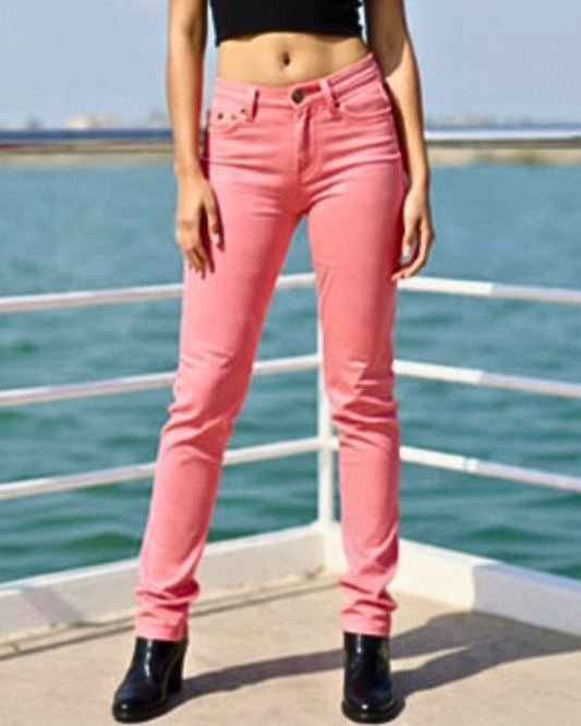 Person wearing pink jeans standing by a waterfront.