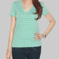 Woman wearing a green striped shirt and dark jeans on a gray background