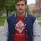 Man wearing a red t-shirt with white text and a blue and gray varsity jacket on a sidewalk.