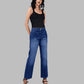 Woman wearing blue jeans and a black top on a gray background