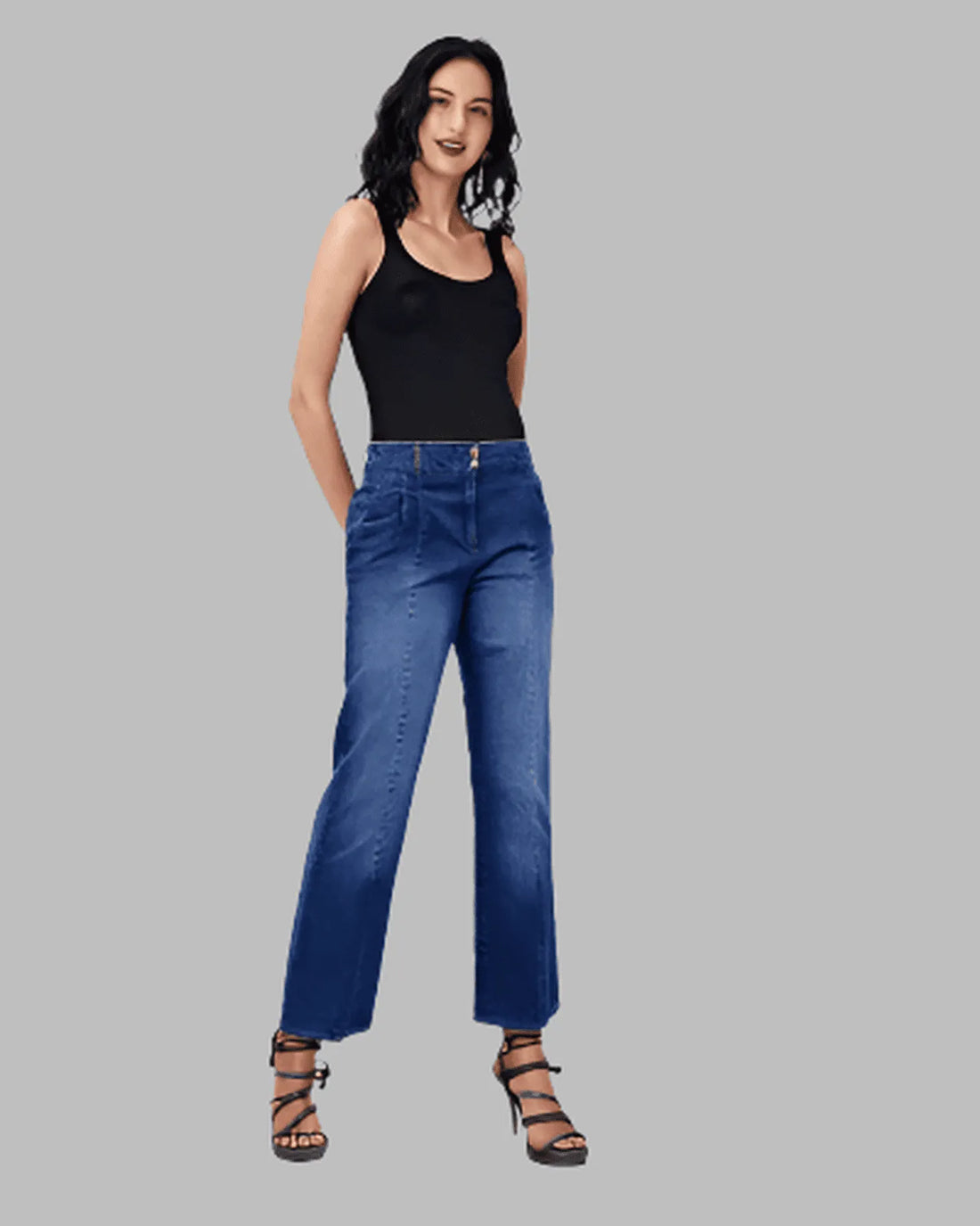 Woman wearing a white blouse and blue jeans on a gray background