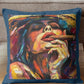 Colorful pillow with artistic depiction of a face on a wooden surface.