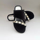 Black sandals with rhinestone embellishments on a light gray background