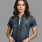 Woman wearing a denim shirt and jeans against a neutral background