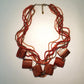 Necklace with red beads and wooden accents on a light background