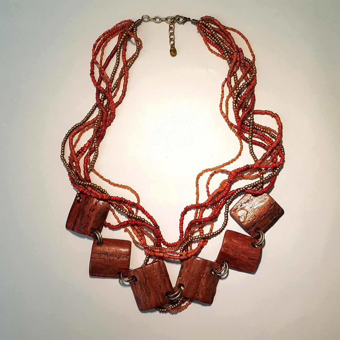 Necklace with red beads and wooden accents on a light background