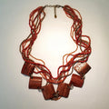 Necklace with red beads and wooden accents on a light background
