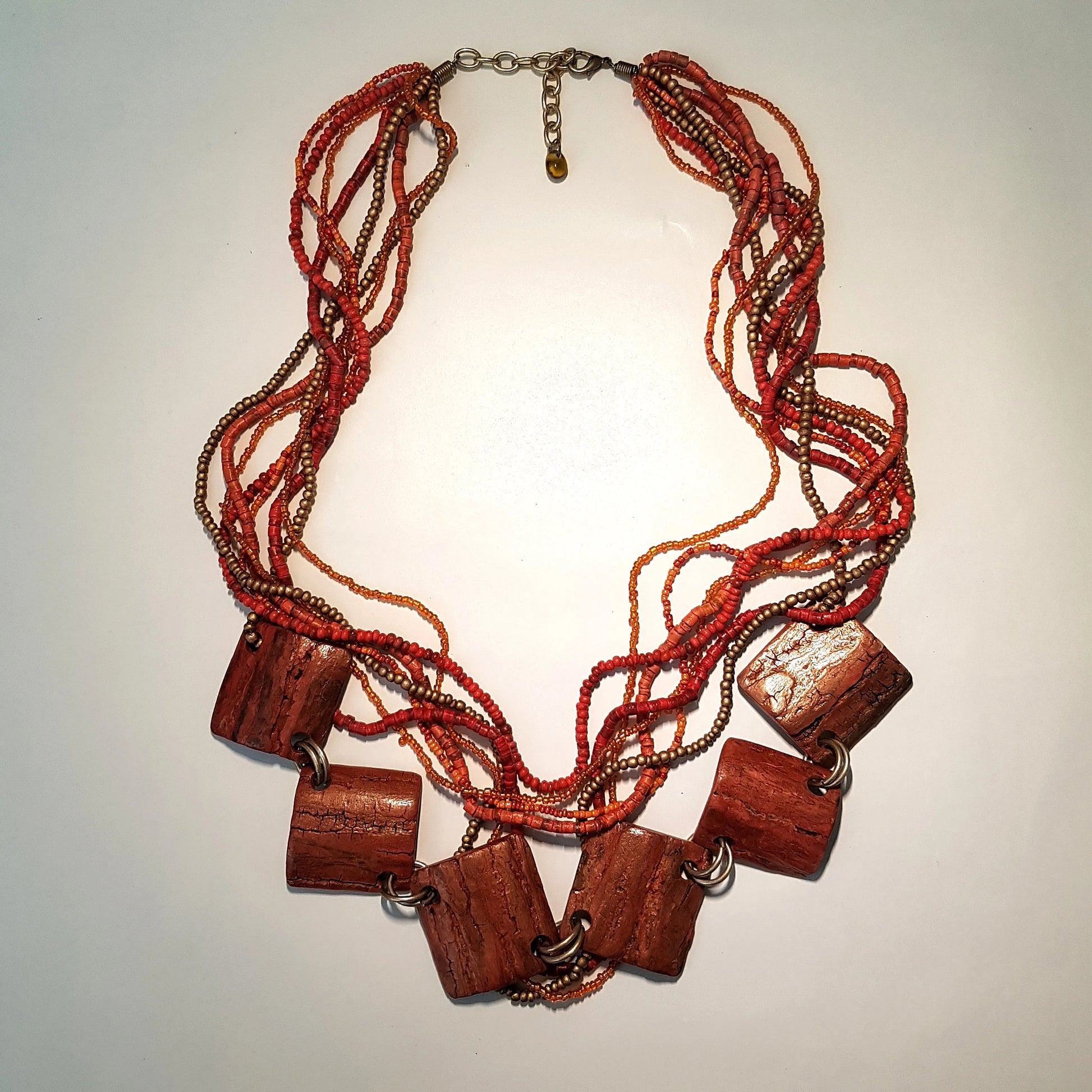 Necklace with red beads and wooden accents on a light background
