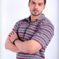 Man wearing a gray and red striped shirt with arms crossed on a white background