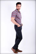 Man wearing a striped polo shirt and dark pants on a white background