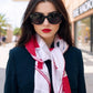 Woman wearing sunglasses and a colorful scarf on a city street