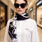 Woman wearing a black and white patterned scarf with a blurred mall background
