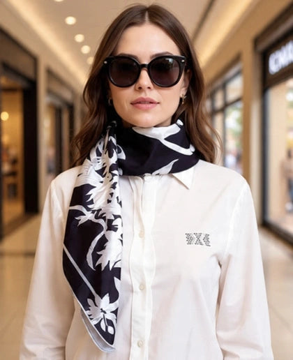 Woman wearing a black and white patterned scarf with a blurred background