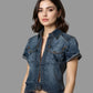 Woman wearing a denim shirt and jeans against a neutral background