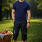 Man standing in a park with a picnic basket and drinks