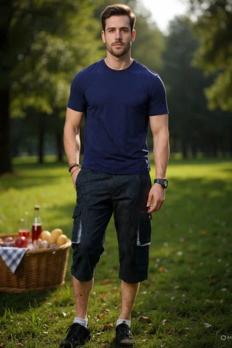 Man standing in a park with a picnic basket and drinks