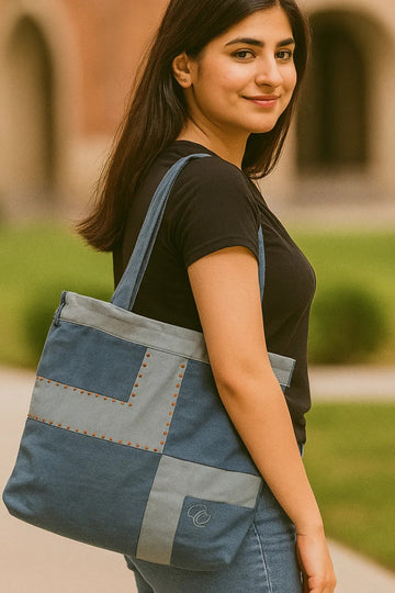 Woman holding a blue tote bag outdoors with a blurred background
