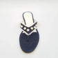 Navy blue sandal with pearl embellishments on a white background