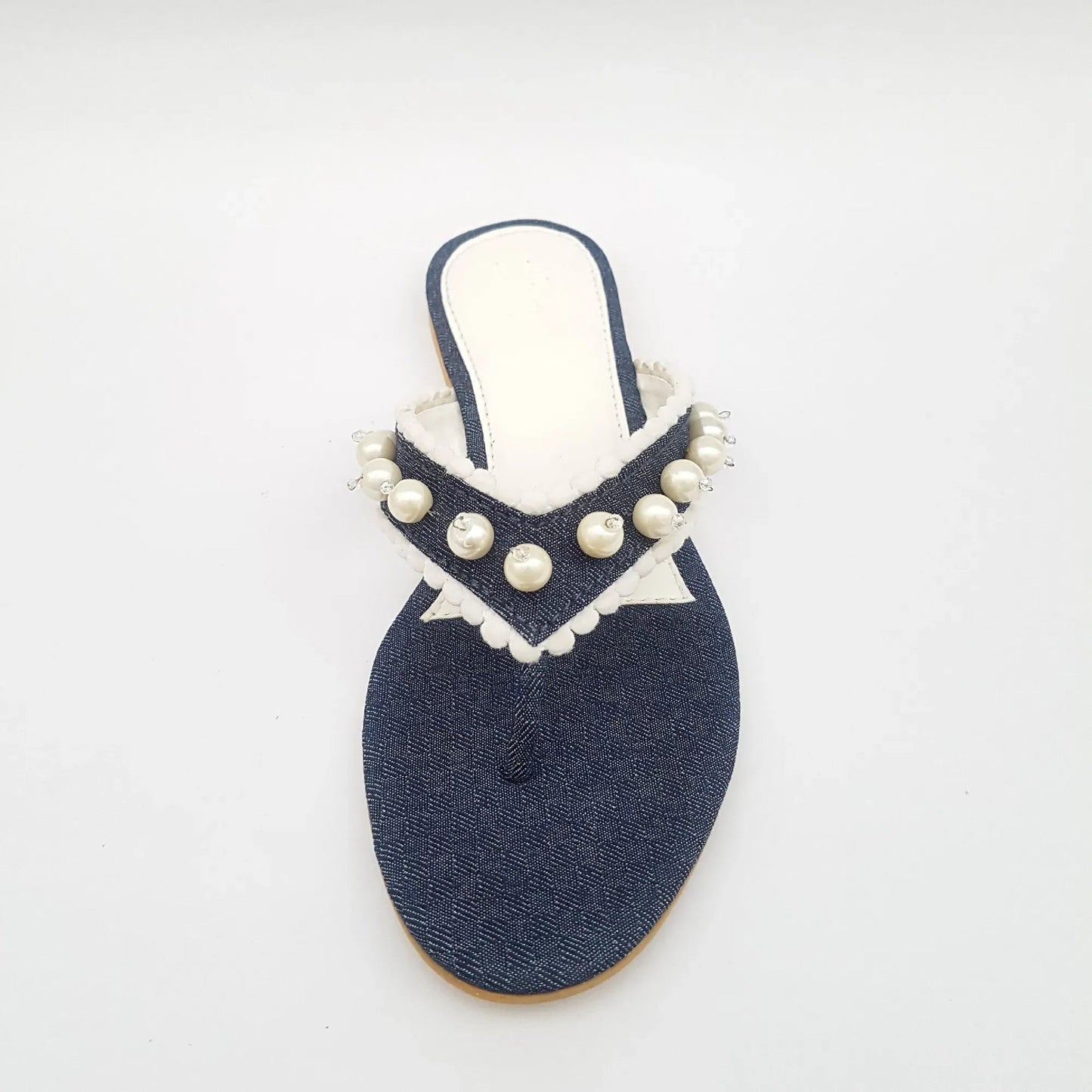 Navy blue sandal with pearl embellishments on a white background