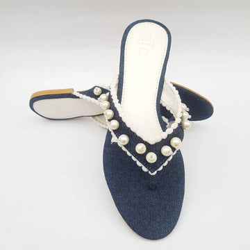 Blue sandal with white pearls on a light gray background