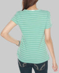 Person wearing a green striped shirt and dark jeans on a gray background