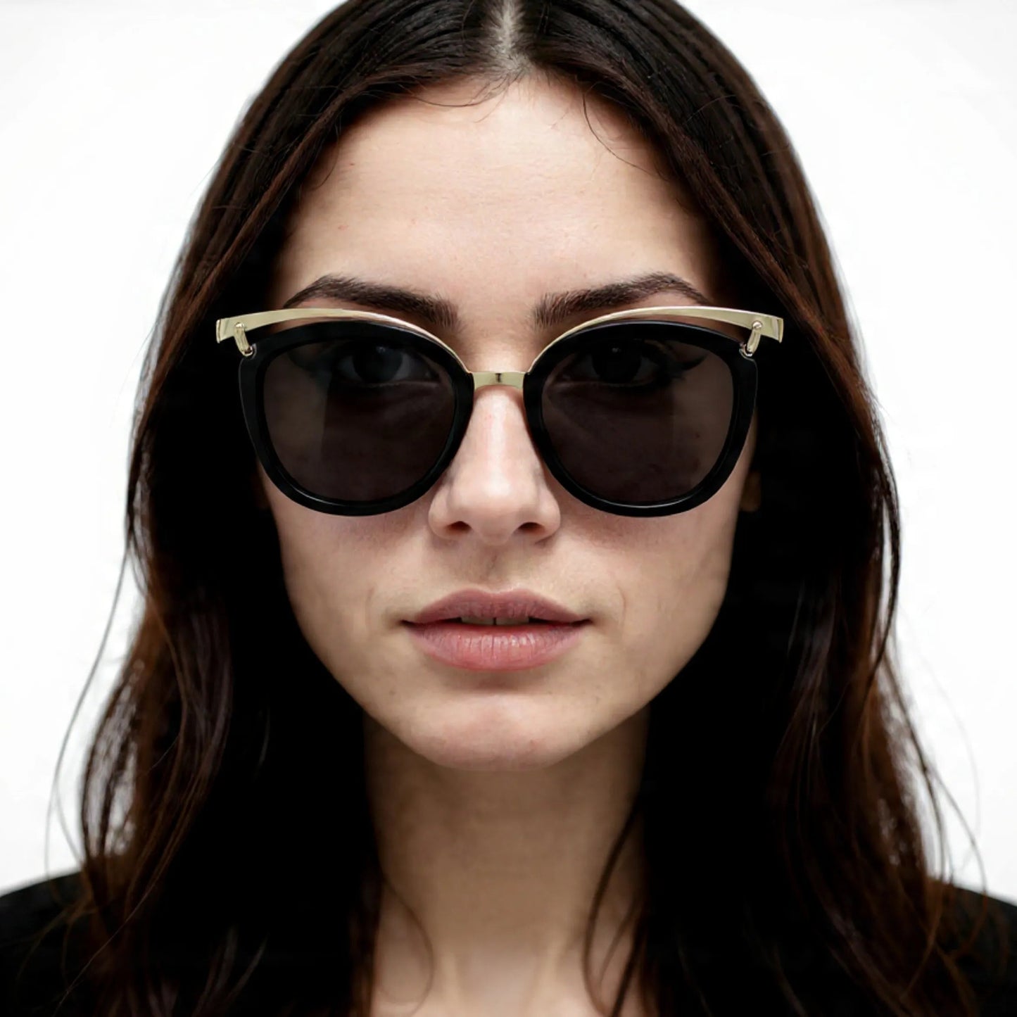 Woman wearing dark sunglasses with a neutral background