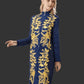 Woman wearing a denim dress with gold embroidery on a dark background