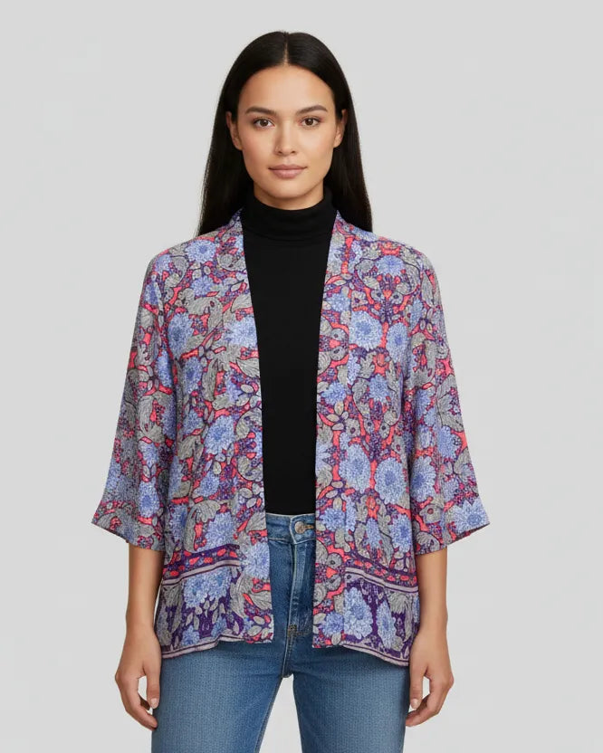 Woman wearing a colorful patterned jacket on a plain background