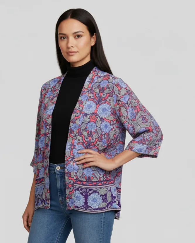 Woman wearing a colorful patterned jacket on a plain background