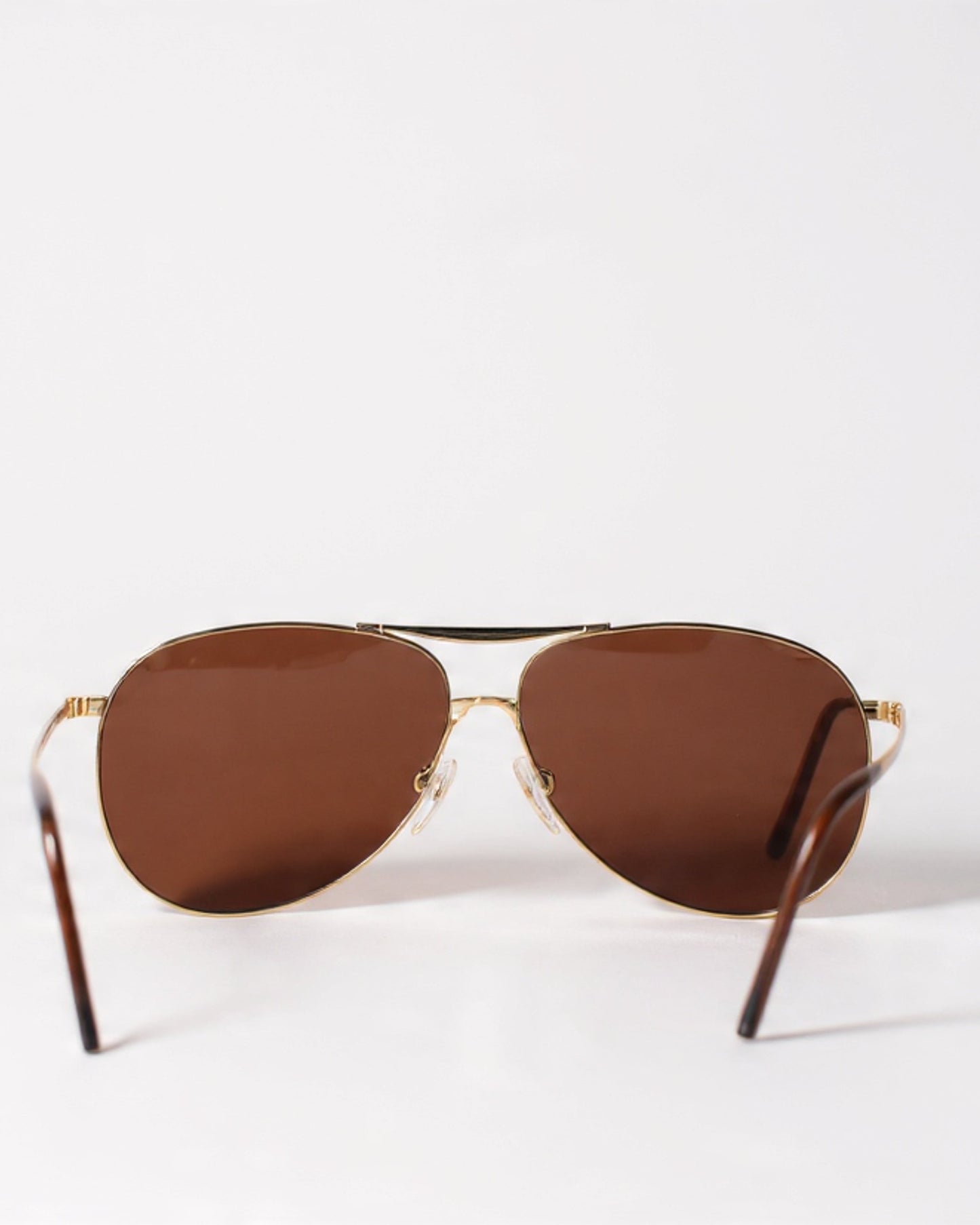 Brown sunglasses with gold frames on a white background